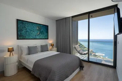 a bedroom with a bed and a view of the ocean at Calheta Hills II by An Island Apart in Estreito da Calheta