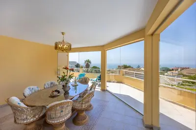 a dining room with a table and chairs and a balcony at Villa Oceana in Luz