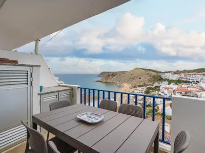 a table on a balcony with a view of the ocean at Retreat with sea view #1973 in Budens