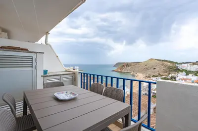 a balcony with a table and a view of the ocean at Retreat with sea view #1973 in Budens