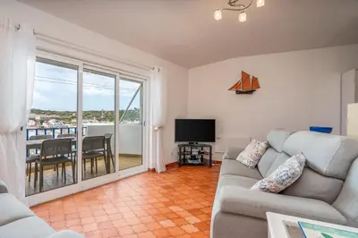 a living room with a couch and a tv and a balcony at Retreat with sea view #1973 in Budens