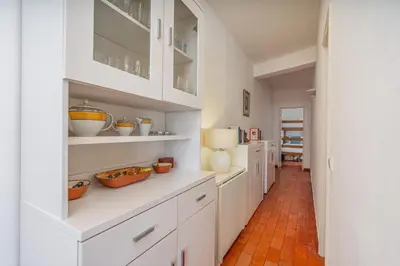 a kitchen with white cabinets and bowls on the shelves at Retreat with sea view #1973 in Budens