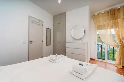 a white bedroom with a white bed and a mirror at Retreat with sea view #1973 in Budens