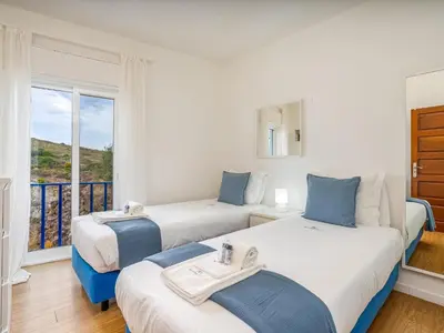 two beds in a room with a balcony at Retreat with sea view #1972 in Budens