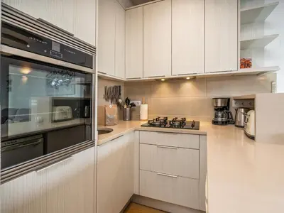 a kitchen with white cabinets and a stove top oven at Retreat with sea view #1972 in Budens
