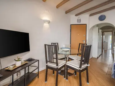 a dining room with a table and chairs and a tv at Retreat with sea view #1972 in Budens