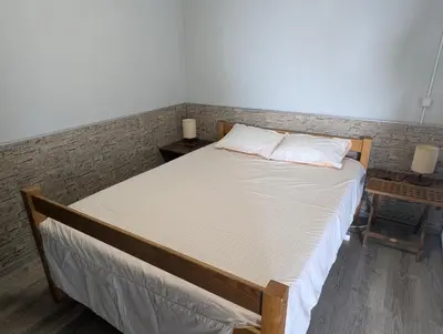 a bedroom with a bed with two night stands and two lamps at Adega Studio in Machico