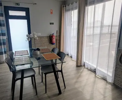 a dining room with a table and chairs and a window at Adega Studio in Machico