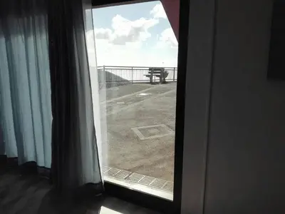 a window with a view of a balcony with a table at Adega Studio in Machico