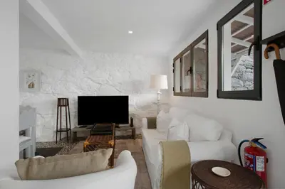 a white dining room with a white table and chairs at The Village Loft in Caniço
