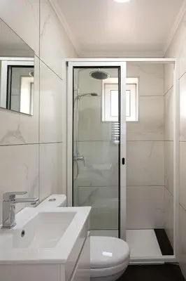 a white bathroom with a sink and a shower at Franco's House II, Mar e Serra in Estreito da Calheta