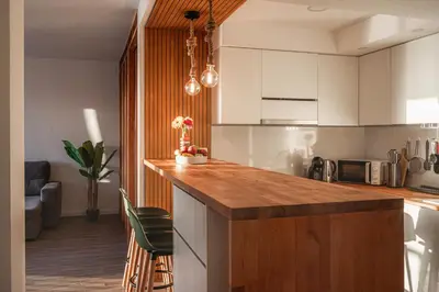 a kitchen with white cabinets and a wooden counter top at High View Apartment in Funchal