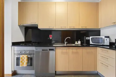 a kitchen with stainless steel appliances and wooden cabinets at Urban Stay 3A by Homie in Funchal