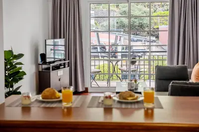 a living room with a table with two plates of food at Pestanas Nest by Homie in Ribeira Brava