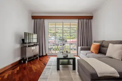 a living room with a couch and a tv at Pestanas Nest by Homie in Ribeira Brava