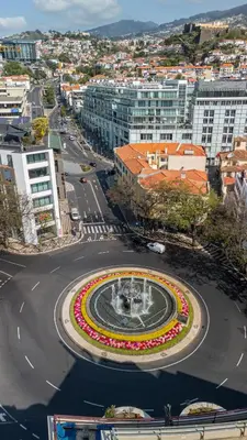 a city with a fountain in the middle of a street at Plaza Residence in Funchal