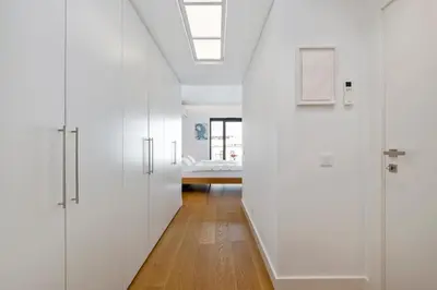 a hallway with white cabinets and a bed in the background at Design Suite at Formosa Beach in Funchal