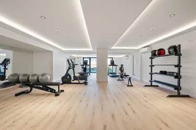 a gym with several treadmills and weights in a room at Design Suite at Formosa Beach in Funchal