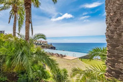 a view of the ocean from a resort with palm trees at Design Suite at Formosa Beach in Funchal