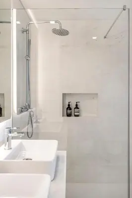 a white bathroom with a sink and a shower at Design Suite at Formosa Beach in Funchal