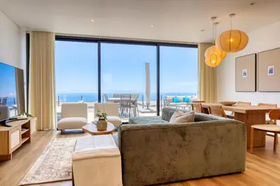 a kitchen and dining room with a wooden table and chairs at Villa Arco-Iris, a Home in Madeira in Arco da Calheta