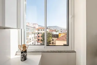 a living room with a couch and a large window at Villa Arco-Iris, a Home in Madeira in Arco da Calheta