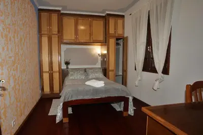 a bedroom with a bed in a room with wooden cabinets at Casa da Cascata in Santana