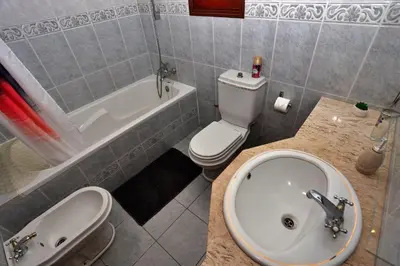 a bathroom with a sink and a toilet and a tub at Casa da Cascata in Santana
