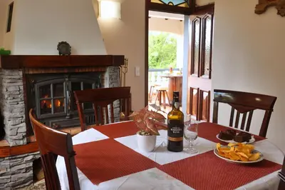 a table with a bottle of wine and a plate of food at Casa da Cascata in Santana