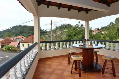a balcony with a table and stools on it at Casa da Cascata in Santana
