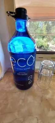 a blue bottle sitting on a counter next to a window at Pauls caravan for 4 - See the horses from your bed in Barão de São João