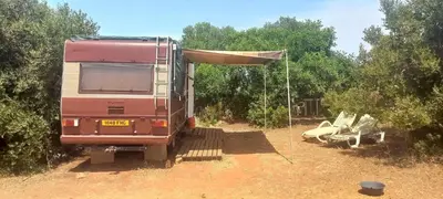 an rv parked in a field with a tent at Pauls caravan for 4 - See the horses from your bed in Barão de São João