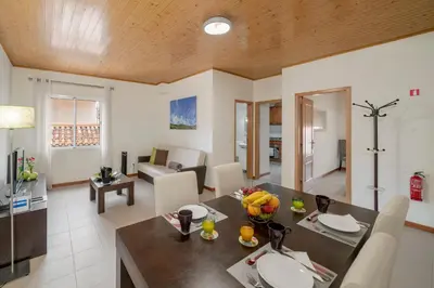 a dining room and living room with a table and chairs at OurMadeira - Taberna Apartments in Funchal