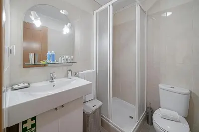 a bathroom with a sink and a shower and a toilet at OurMadeira - Taberna Apartments in Funchal