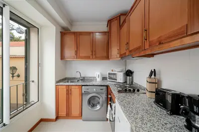 a kitchen with a washer and a washing machine at OurMadeira - Taberna Apartments in Funchal