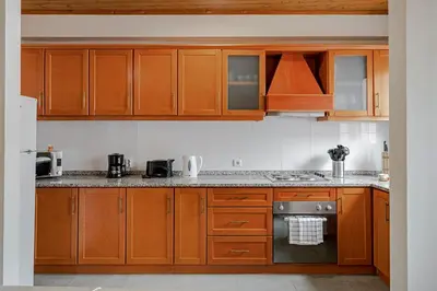 a kitchen with wooden cabinets and a stove top oven at OurMadeira - Taberna Apartments in Funchal