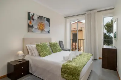 a bedroom with a large bed and a balcony at OurMadeira - Taberna Apartments in Funchal