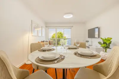 a white dining room with a white table and chairs at Naval View By Links in Funchal