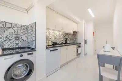 a kitchen with a washer and a washing machine at Naval View By Links in Funchal