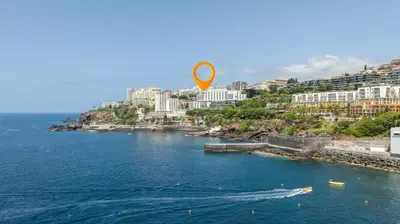 an orange kite flying over a body of water at Naval View By Links in Funchal