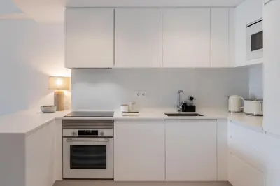 a white kitchen with white cabinets and an oven at Acqua Residence VI by An Island Apart in Funchal