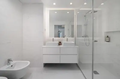 a white bathroom with two sinks and a shower at Acqua Residence VI by An Island Apart in Funchal