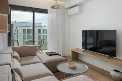 a living room with a couch and a flat screen tv at Acqua Residence VI by An Island Apart in Funchal