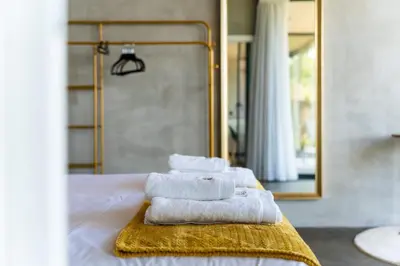 a group of towels sitting on a bed in front of a mirror at GuestReady - Relax & Ride the Waves in São Vicente