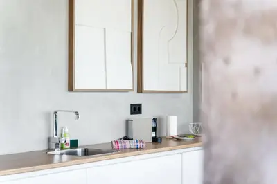 a kitchen counter with a sink and two mirrors at GuestReady - Relax & Ride the Waves in São Vicente