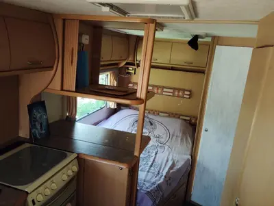 a small kitchen with a bed in an rv at Uljanas caravana for 2 with view of the rescued horses in Barão de São João