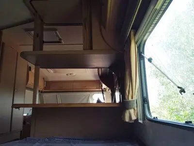 a small room with a window on a train at Uljanas caravana for 2 with view of the rescued horses in Barão de São João