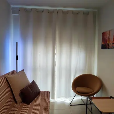 a bedroom with a bed and a chair and a window at Sol II in Funchal