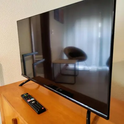 a television sitting on a table with a remote control at Sol II in Funchal