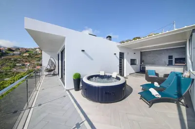 a patio with a hot tub on top of a house at Ocean Valley by Mth in Ribeira Brava